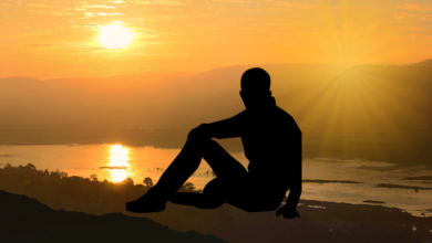 Silhouette of a person meditating at sunset over a river