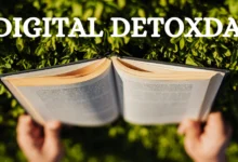 Open book held by hands with green leaves in the background and "DIGITAL DETOXDAY" text overlay.