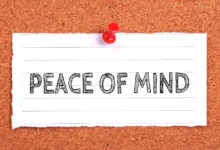 A piece of lined paper pinned to a corkboard with the words "PEACE OF MIND" written in bold, sketch-style letters.