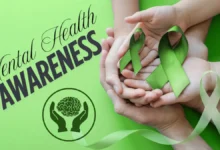 Hands holding green ribbons for mental health awareness and support.