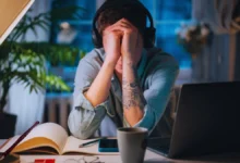 Stressed person with head in hands at desk, showing mental exhaustion