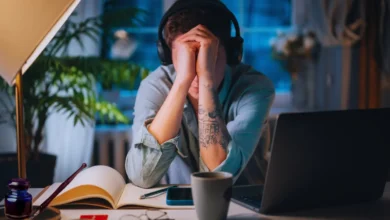 Stressed person with head in hands at desk, showing mental exhaustion