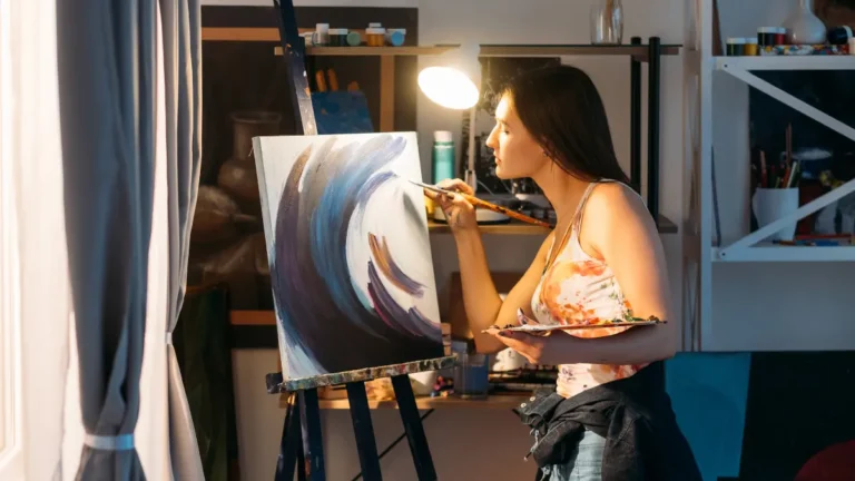 Woman painting on canvas during art therapy session for mental health improvement