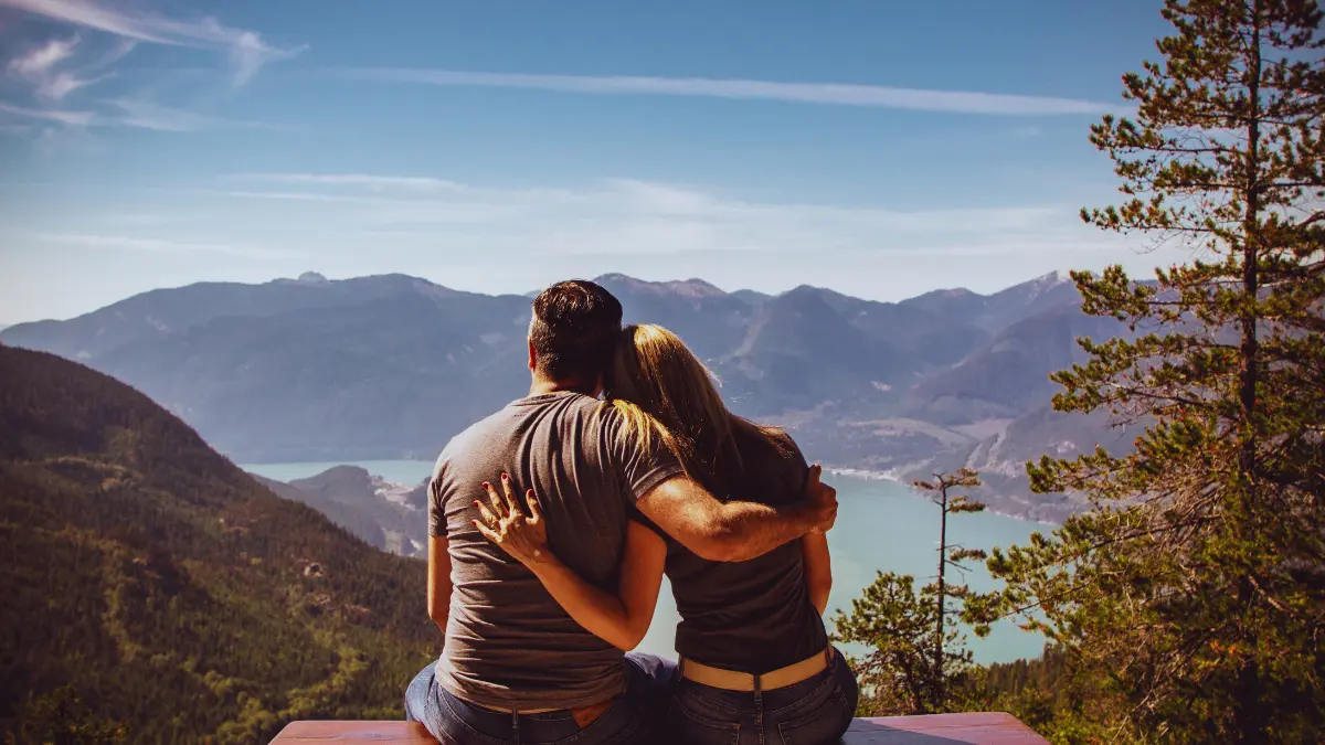 Couple sitting peacefully on a mountain, symbolizing emotional healing and mental peace.