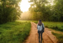 Person walking quietly through forest at sunrise, practicing silent walking for mental clarity
