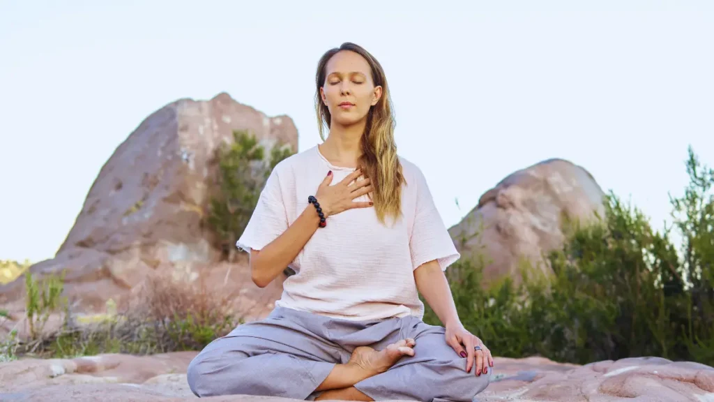 Woman practicing mindfulness in nature, reflecting Wellness Trend Awareness and mental clarity.
