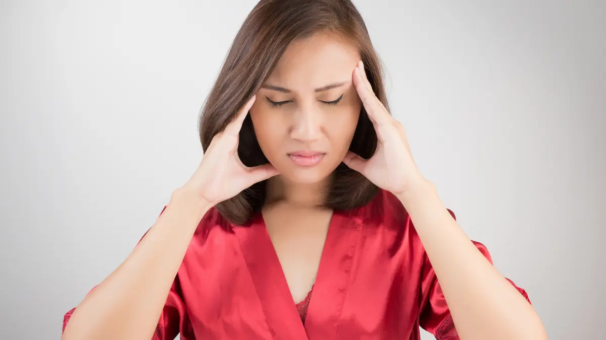 Stressed woman holding her head, showing hidden signs of mental exhaustion