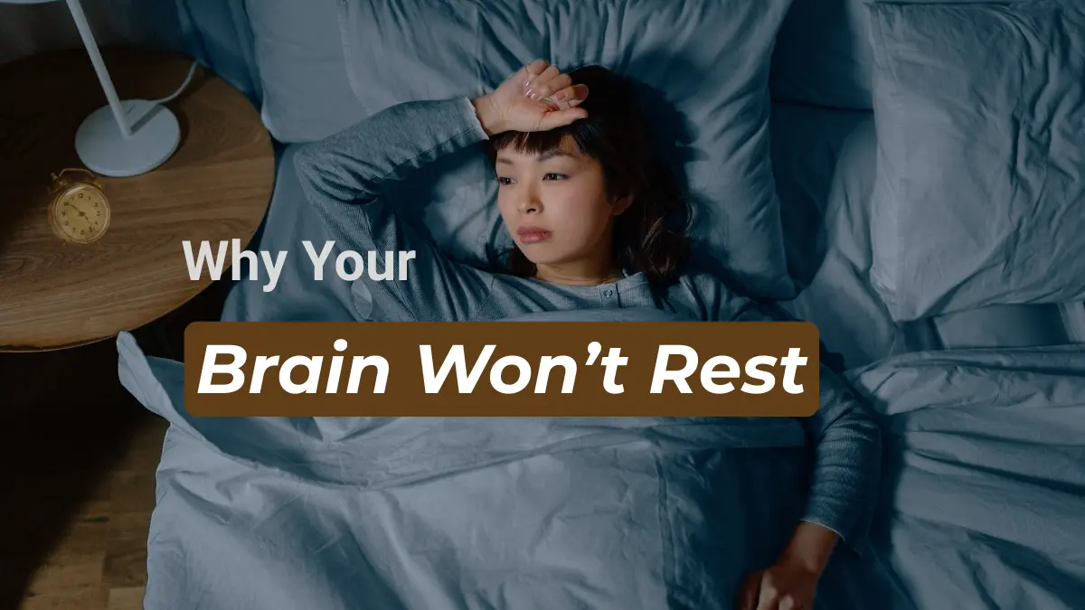 Woman lying awake in bed at night, showing signs of racing thoughts and overthinking before sleep.